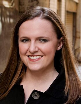 Smiling woman with long brown hair and light makeup.