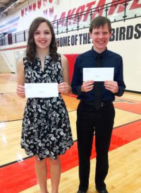 Two young people holding certificates in a gymnasium.