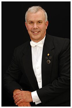 A man in formal attire with medals on his jacket.