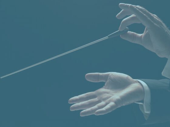 A gloved hand holding a long medical swab stick.
