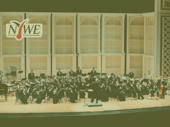 Symphony orchestra performing on stage in a concert hall.