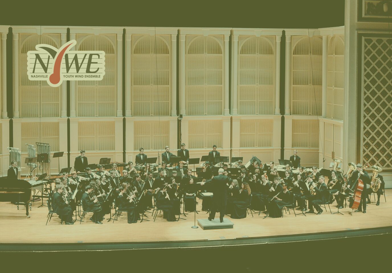 Symphony orchestra performing on stage in a concert hall.